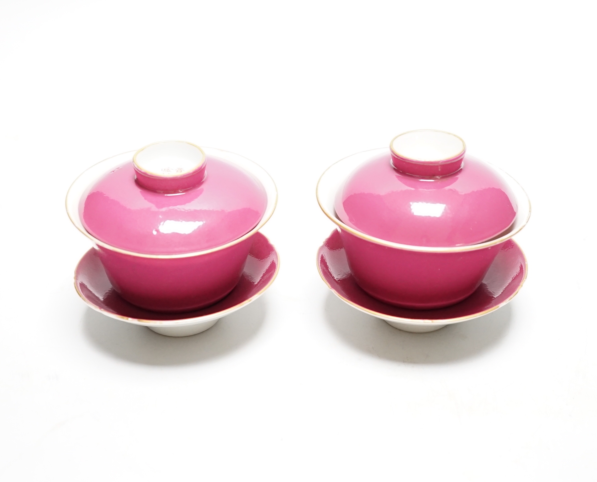A pair of Chinese ruby ground tea bowls, covers and stands